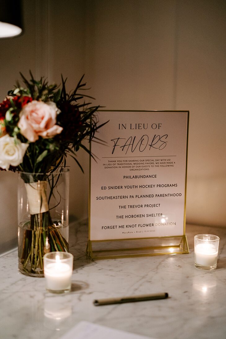 Sign Representing Donation Gifts From the Couple, Candles and Bouquet in Vase