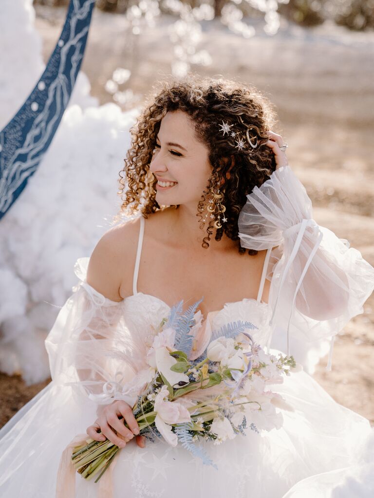 Bride wearing celestial-themed wedding dress with star and moon hair pins and earrings