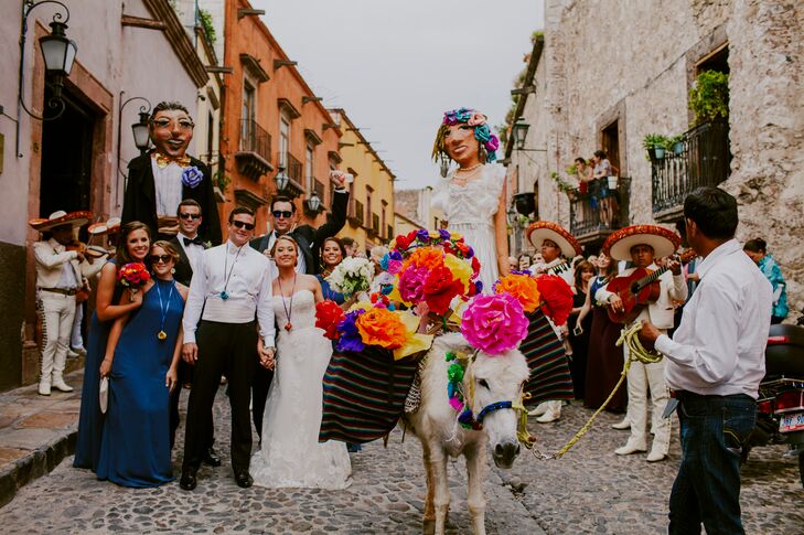 After exchanging vows in a traditional Catholic ceremony at Templo de la Inmaculada Concepcion, Marian and Dillion led their families and friends through the streets of San Miguel de Allende, Mexico, in a customary callejoneada. A donkey adorned with colorful paper flowers led the procession, with a mariachi band and puppets made in the likeness of the couple adding a festive flair to the parade.