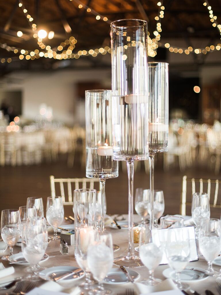 simple tall wedding centerpiece with floating candles in glass vases at different heights