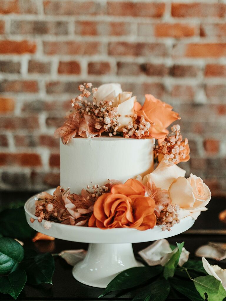 simple one-tier fall wedding cake decorated with orange roses and baby's breath