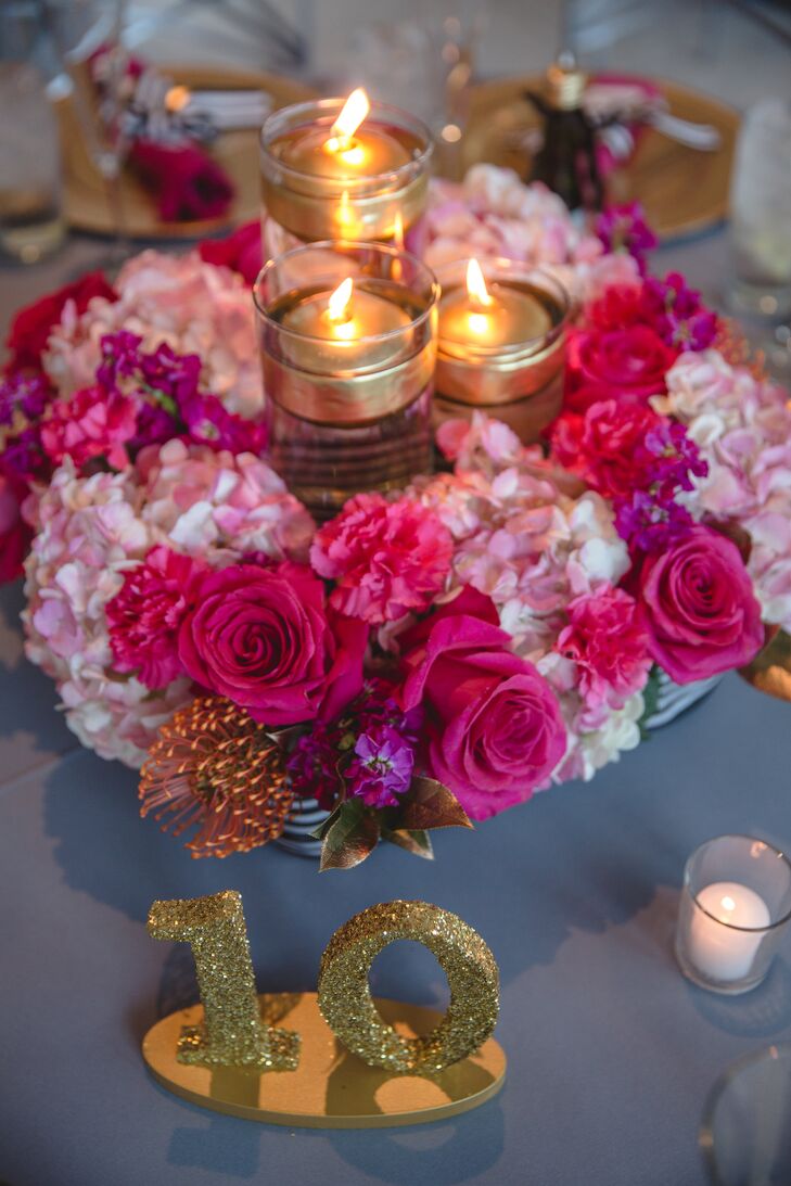 Natalie and Mark's centerpieces of fuchsia roses and pink hydrangeas in black-and-white boxes allowed for easy conversation at dinner. The arrangements also had touches of gold leaves and mixed high and low candles.