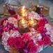 Natalie and Mark's centerpieces of fuchsia roses and pink hydrangeas in black-and-white boxes allowed for easy conversation at dinner. The arrangements also had touches of gold leaves and mixed high and low candles.