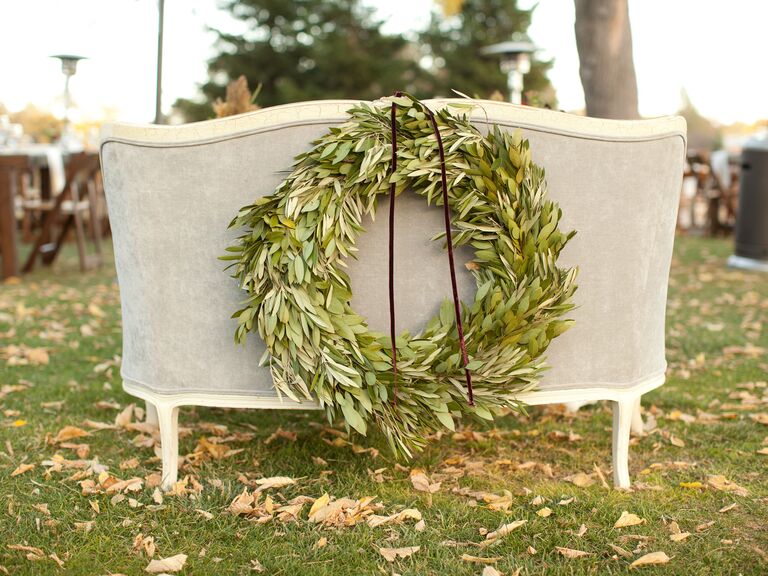 the back of a gray velvet settee decorated with greenery wreath