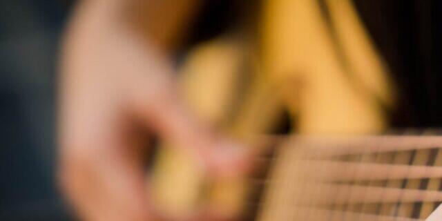 Picture of A purple sweater & acoustic guitar. 