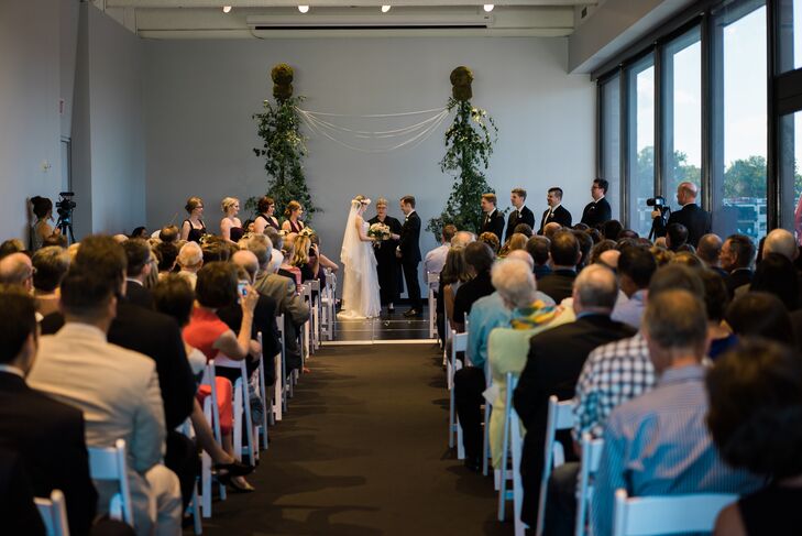 Tessa and Brendan exchanged vows in the Garden Terrace room of the Walker Art Center in Minneapolis, Minnesota. They loved the oversize windows overlooking the terrace and the sculpture garden. With gorgeous vistas and a short ceremony, the couple kept their ceremony decor minimal. Martha’s Gardens created the small trellis wedding arbor, including potted trees, smilax vines and ribbons.