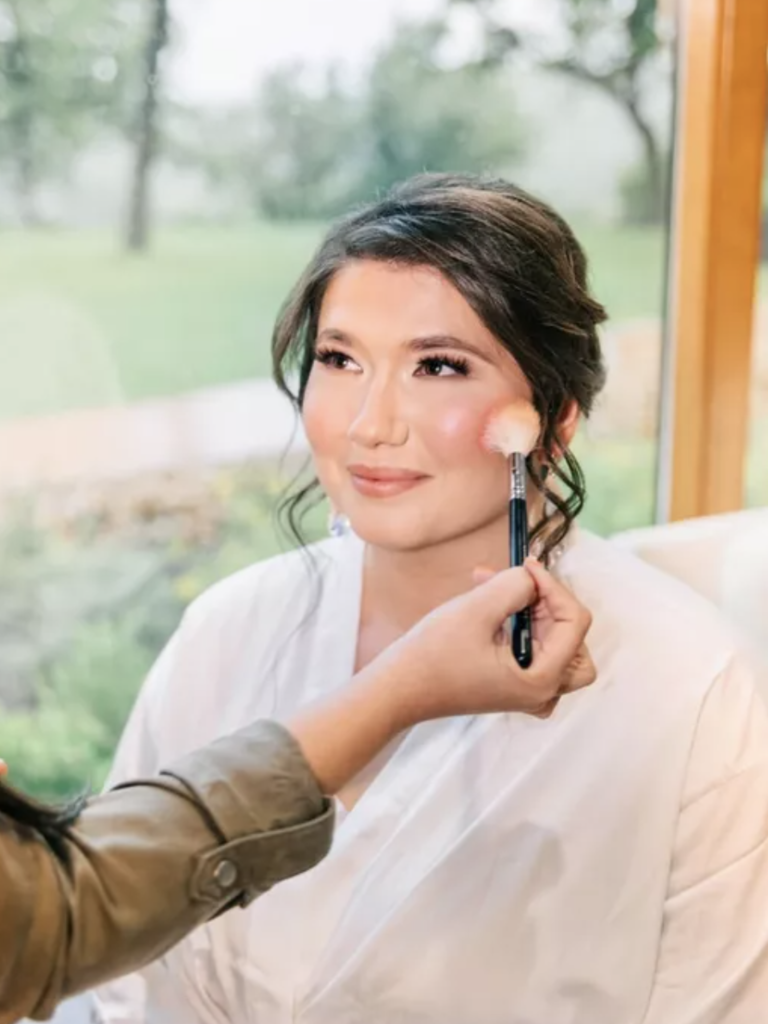 bride with updo getting makeup touched up
