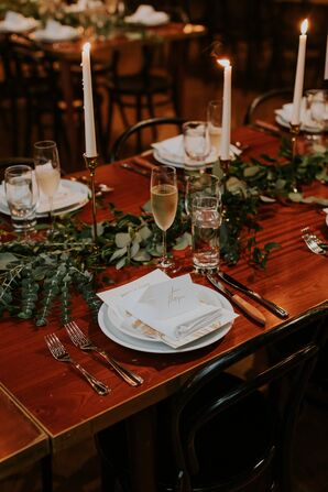 Long Wood Table With White Charger and Menu, Candles and Greenery Runner