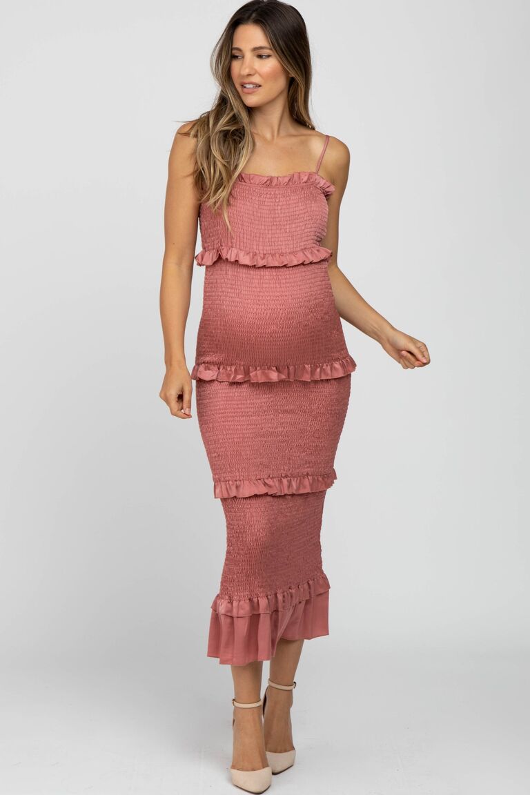 Model wears a smocked pint maternity dress by PinkBlush. 