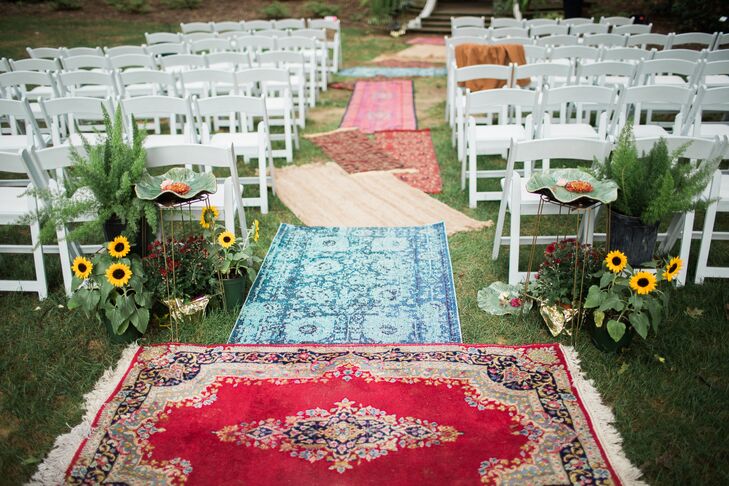 Overlapping, colorful rugs functioned as an eclectic aisle runner and brightened the organic ceremony space.