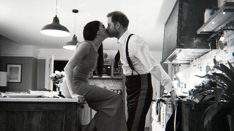 Meghan Markle and Prince Harry kissing in their kitchen at home