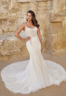 Woman posing in Casablanca Bridal wedding gown in front of stone wall