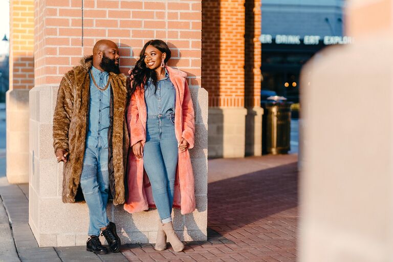 Couple smiling at each other while wearing denim outfits and coats