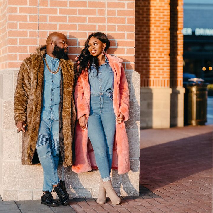 Couple smiling at each other while wearing denim outfits and coats