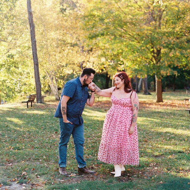 A kiss on the hand outdoor engagement photo idea
