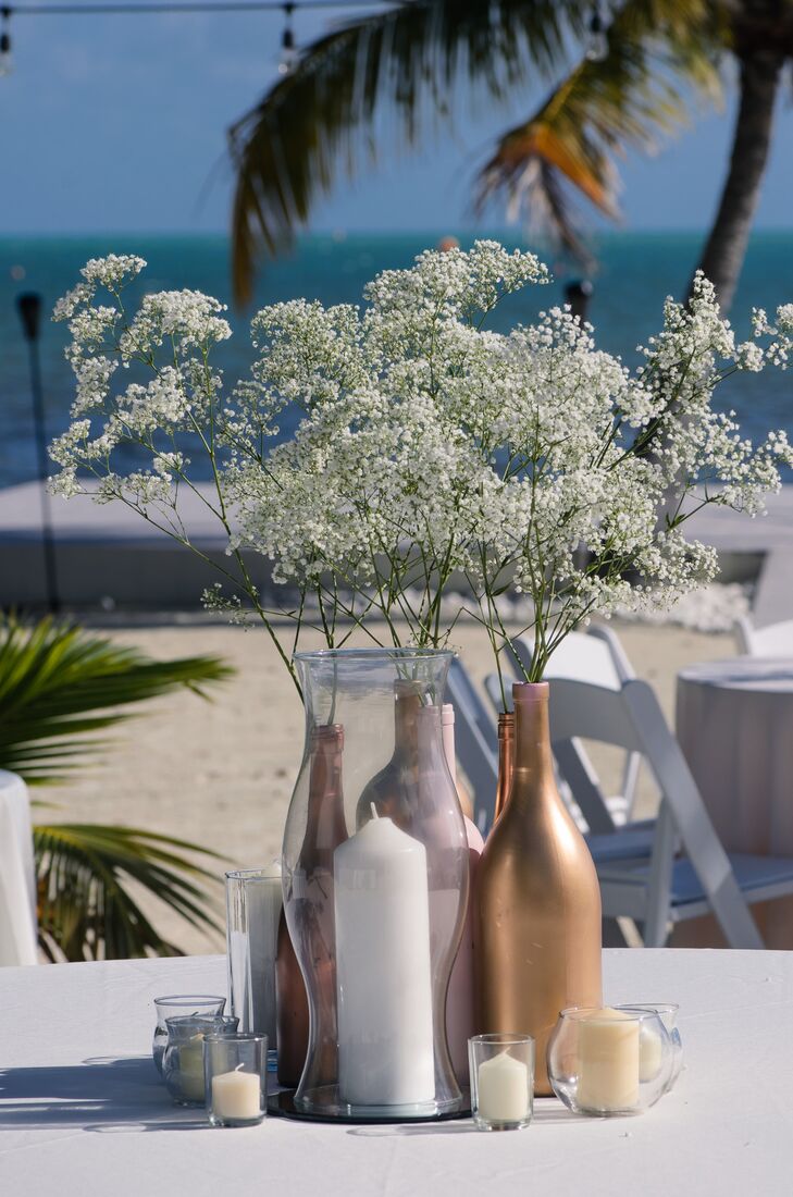Kristen and Damien chose different sized candles as well as champagne and bronze colored bottles filled with baby’s breath for their centerpieces.
