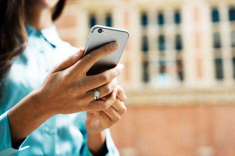 Woman holding phone with an engagement ring on 