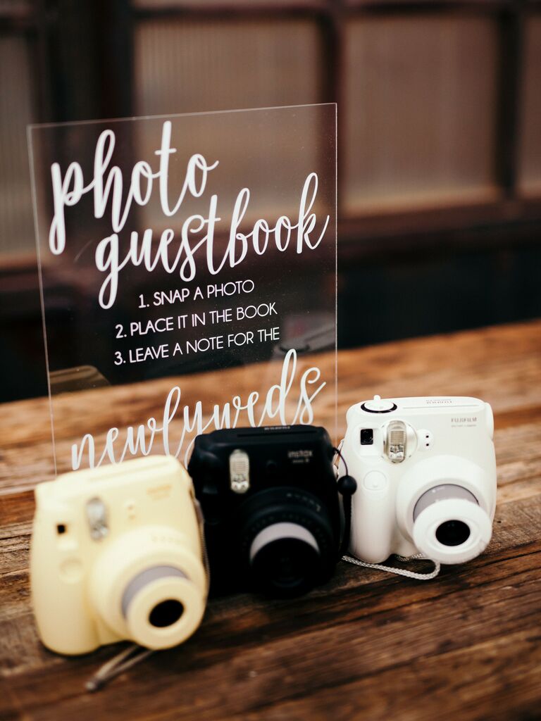 Polaroid cameras sitting on table with acrylic sign