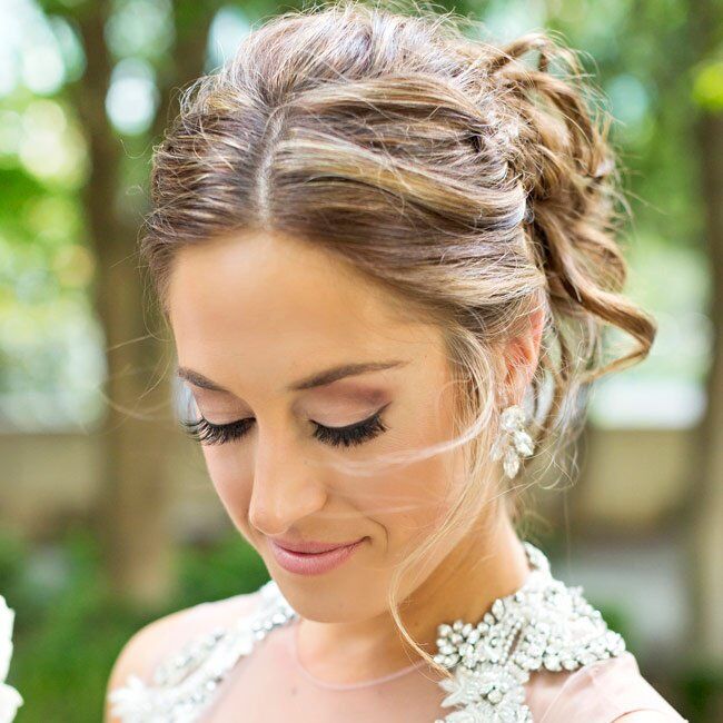 The bride wore her hair up in a curled and braided loose chignon with soft tendrils framing her face.