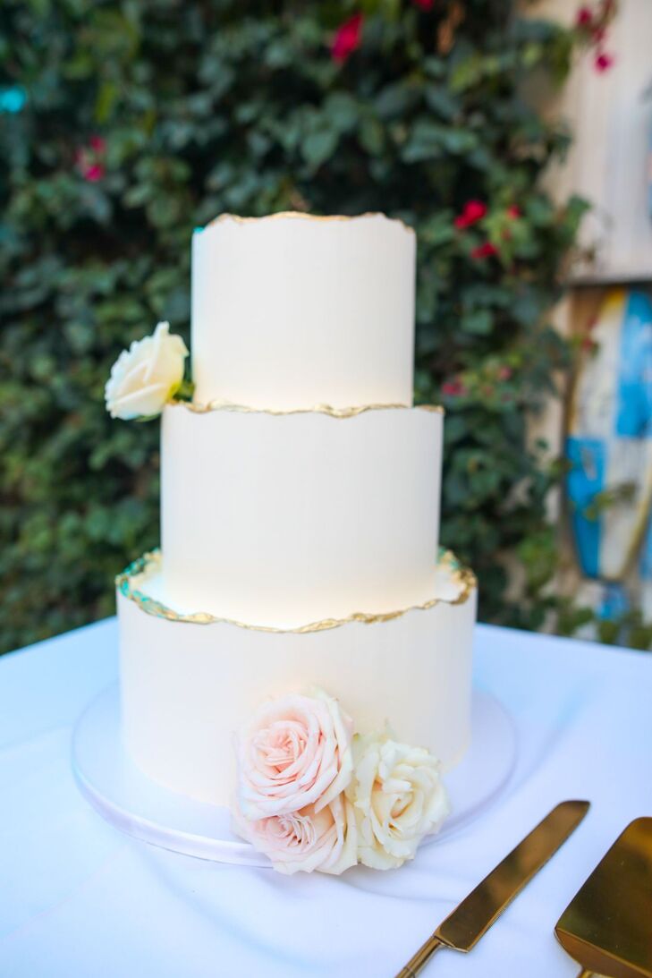 Three-Tier White Wedding Cake With Gold Hem and Real White-and-Blush Roses