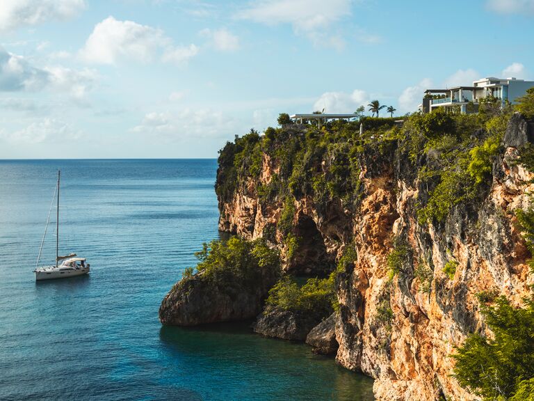 Tropical Cliff side with a home and sailboat