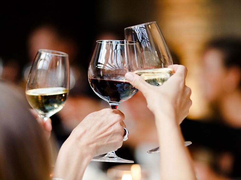 Rehearsal dinner guests toasting wine glasses