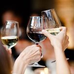 Rehearsal dinner guests toasting wine glasses