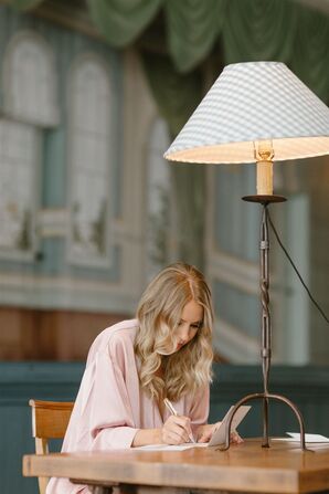 Bride in a Pink Robe Before Wedding Writing a Letter to Her Groom
