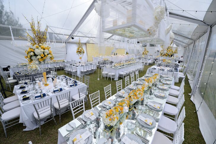 Guests enjoyed a four-course meal inside a transparent wedding tent decorated with yellow and silver details.