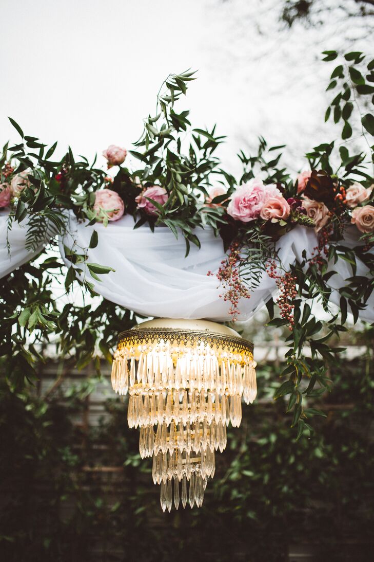 The piece de resistance that brought an element of old-world glamour to Morgan and Stanley’s wedding arch was the addition of a tiered crystal chandelier. The luxe lumiere worked with a cluster of ivory pillar candles to cast a warm, ambient glow over the couple as they exchanged vows.