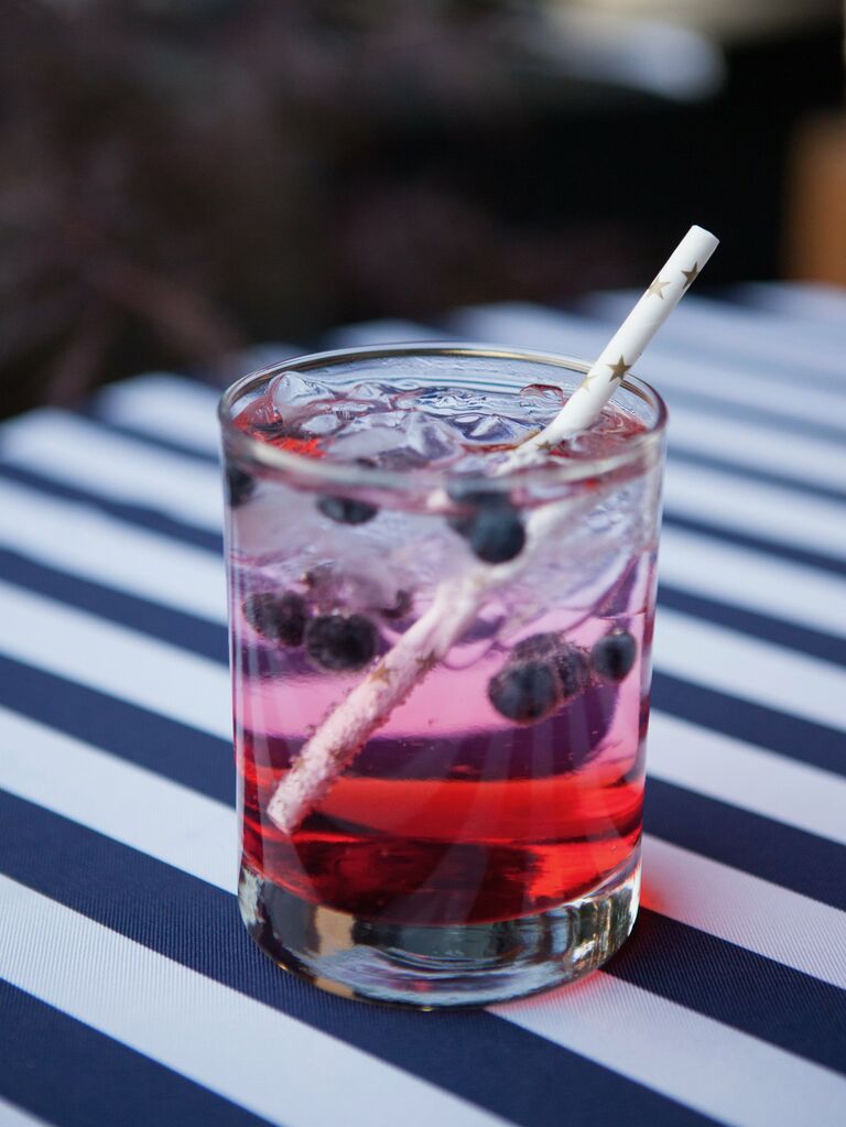 blueberry vodka lemonade signature cocktail with fresh blueberries served with paper straw