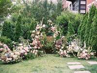 Whimsical pastel floral arrangement around oudoor wedding ceremony altar