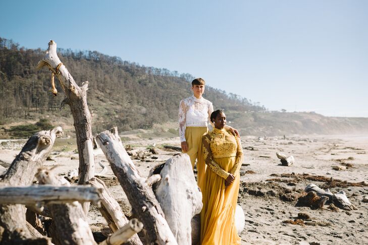 Bride in Two-Piece, Yellow Gown and Partner in Lace Top, Slacks on Driftwood Beach