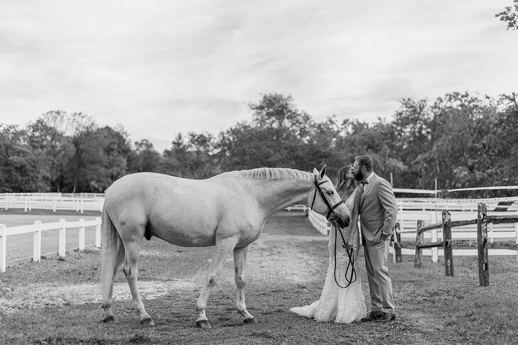Black and White Photo of the Bride's Horse on a Ranch, Bride and Groom Kissing