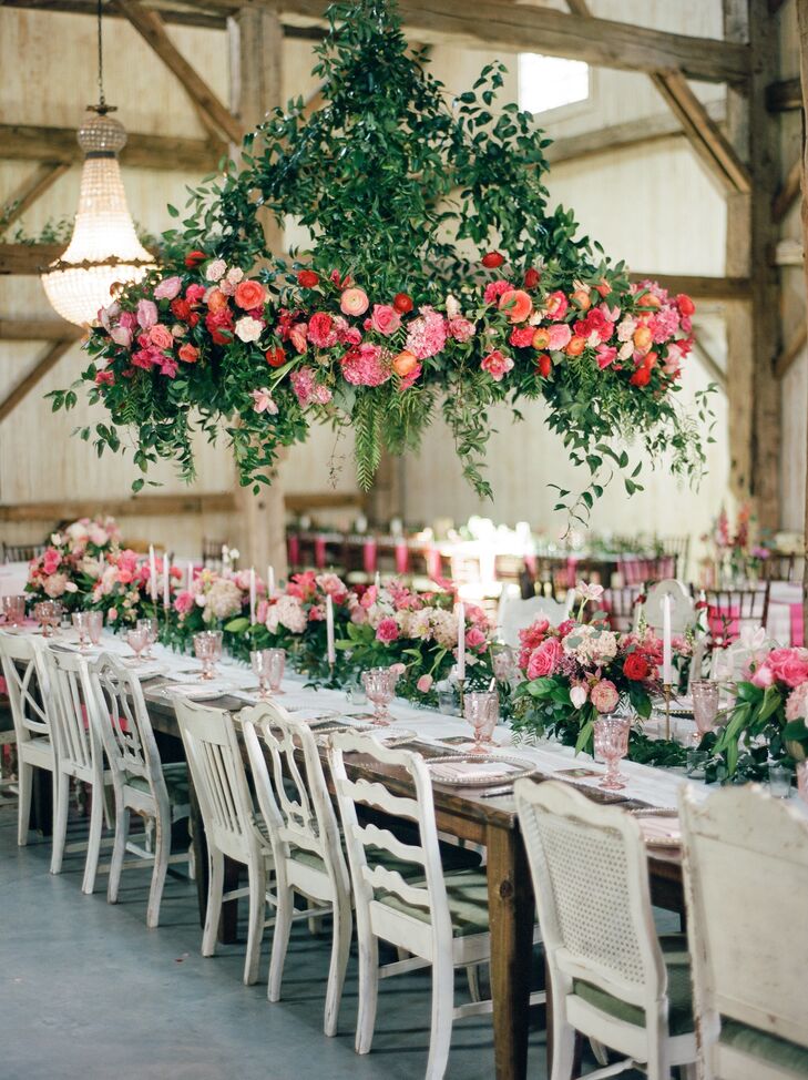 A luscious six-foot flower chandelier hung over the banquet table at the barn reception at Chandelier Grove in Tomball, Texas. It was crafted with peonies, garden roses and lots of greenery.