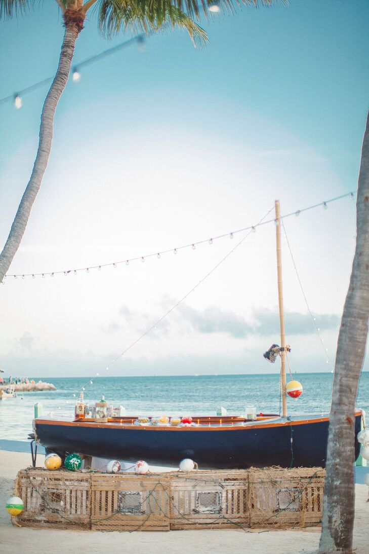 Before sitting down to dinner, guests enjoyed cocktail hour on the beach. Drinks were served at a bar setup inside a sailboat along the water, playing up the day’s beachy, nautical theme.rn