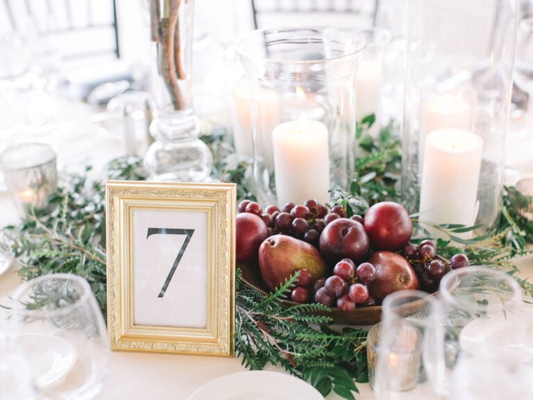 elegant fall wedding centerpiece with red grapes, apples and greenery
