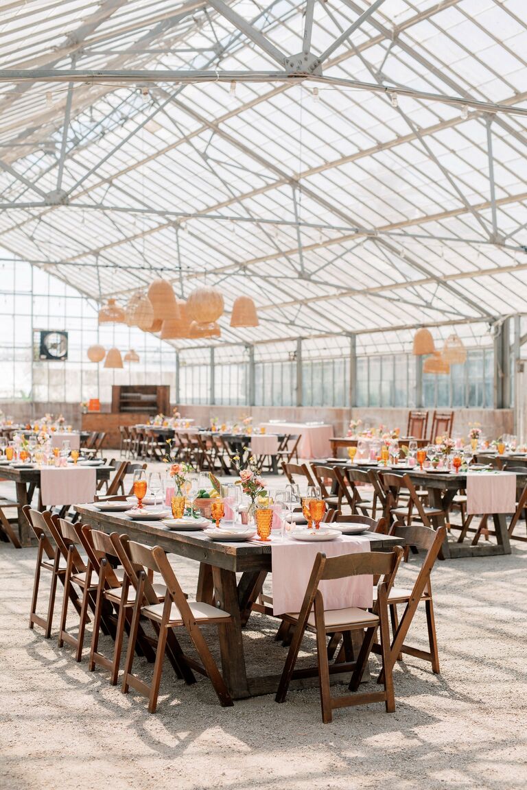 Greenhouse wedding reception with woven chandeliers and farm tables