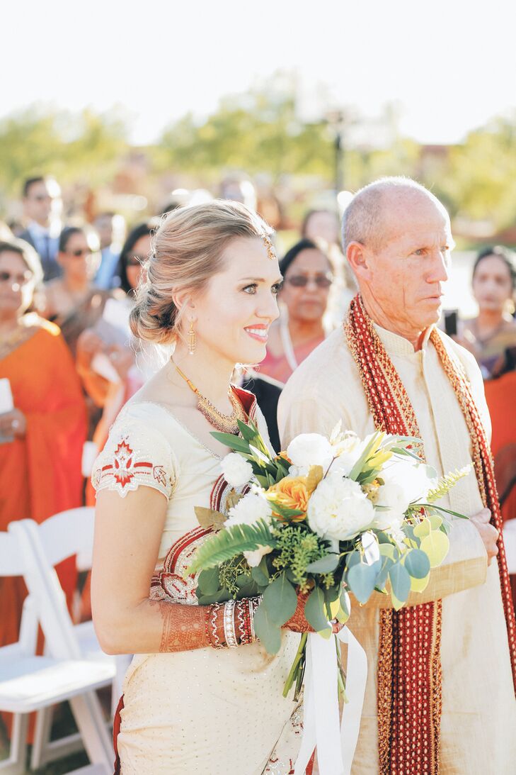 The bride’s bouquet included loose white peonies, ranunculus, gold roses, and foliage.