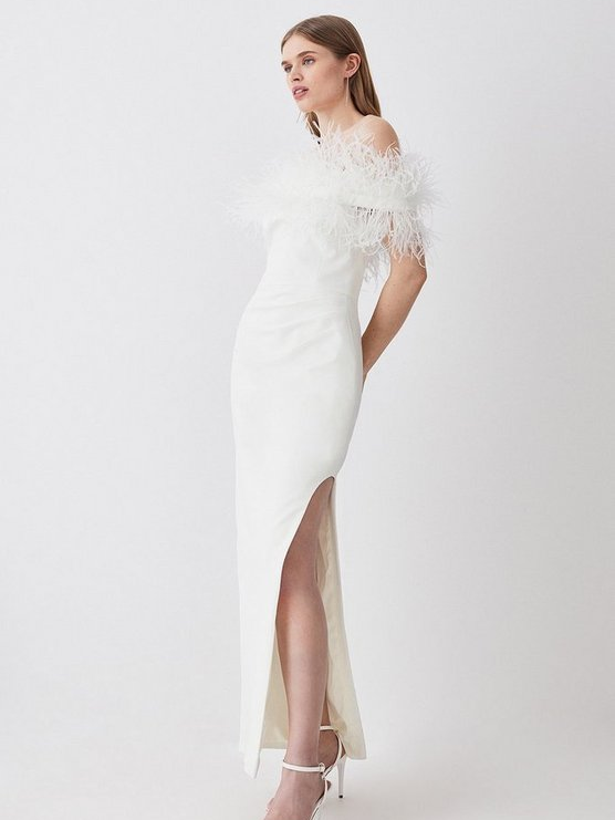 A model wears this lovely white floor-length gown with a high slit.
