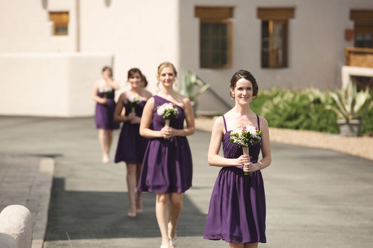 The bridesmaids wore eggplant purple dresses in different styles, while carrying simple, romantic bouquets wrapped in burlap.