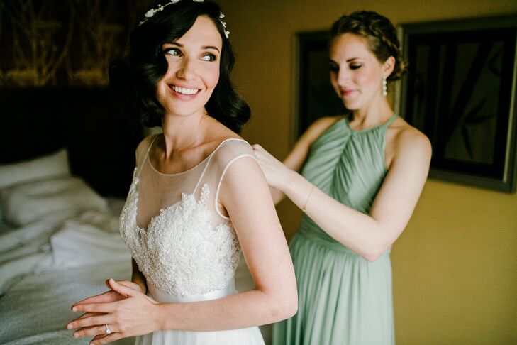 “My priority when it comes to clothing is that it's comfortable, so my wedding dress was no exception,” Janel says. On their wedding day, she slipped on the stunning Watters gown from Lovely Bridal Shop. Chic lace detailing and delicate beading covered the bodice below an illusion neckline. A white ribbon sash wrapped around her waist, distinguishing it from the pleated white skirt.