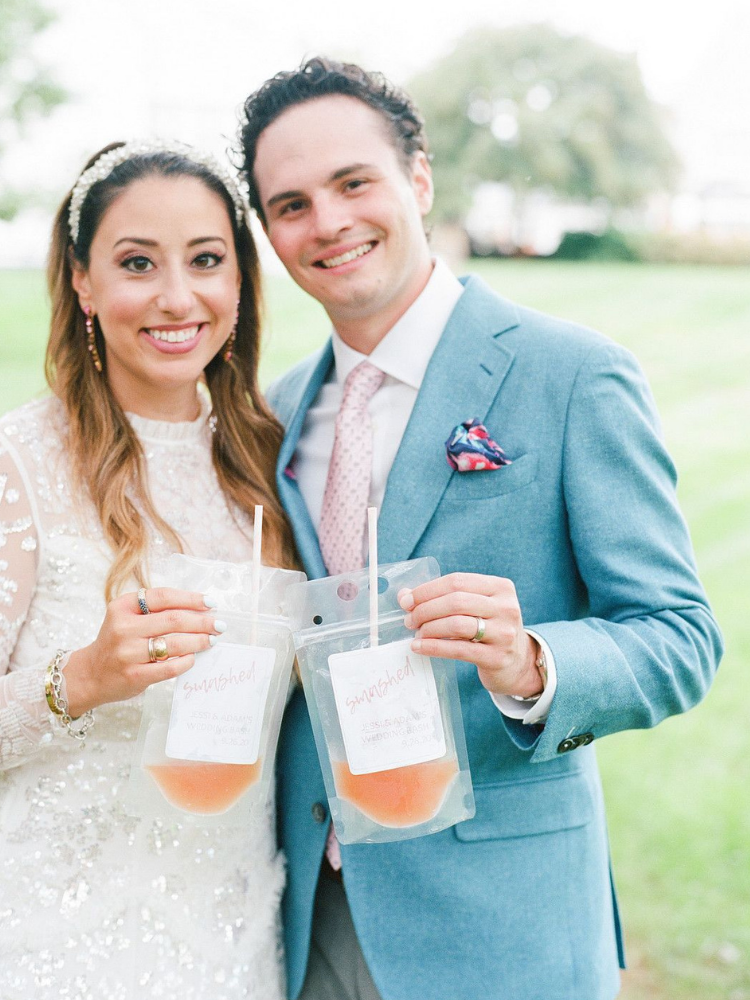Couple holding wine in drink pouches
