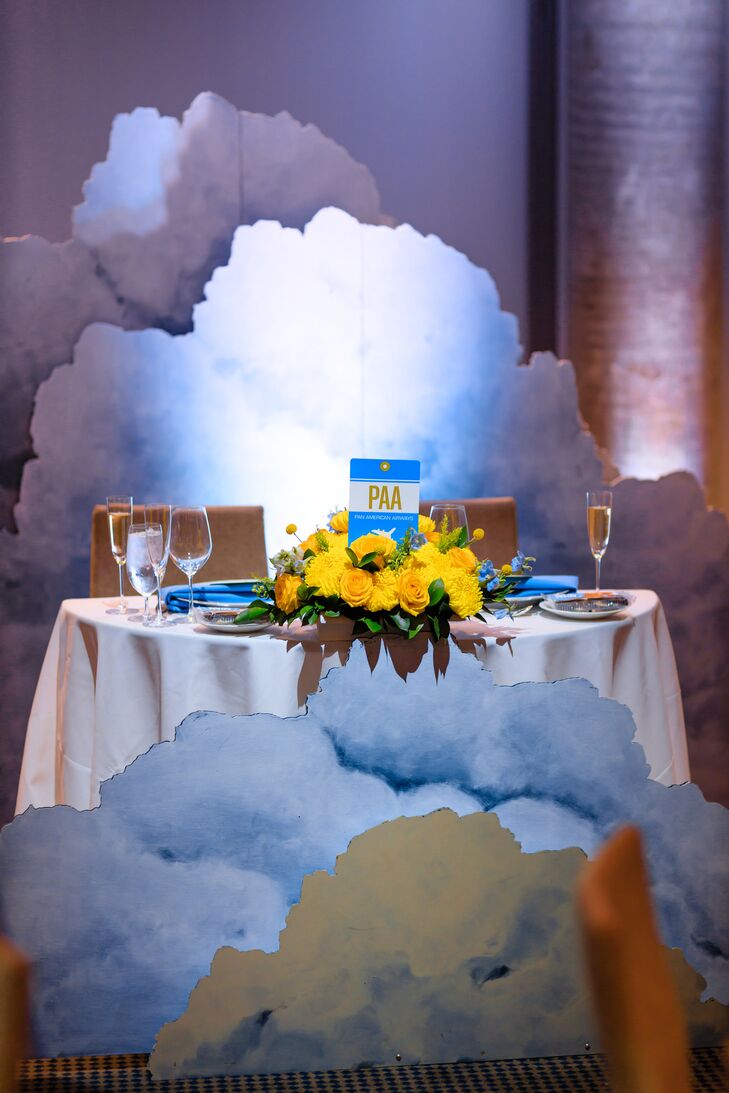 Whimsical Sweetheart Table with Cloud Decorations and Yellow Flower Centerpieces