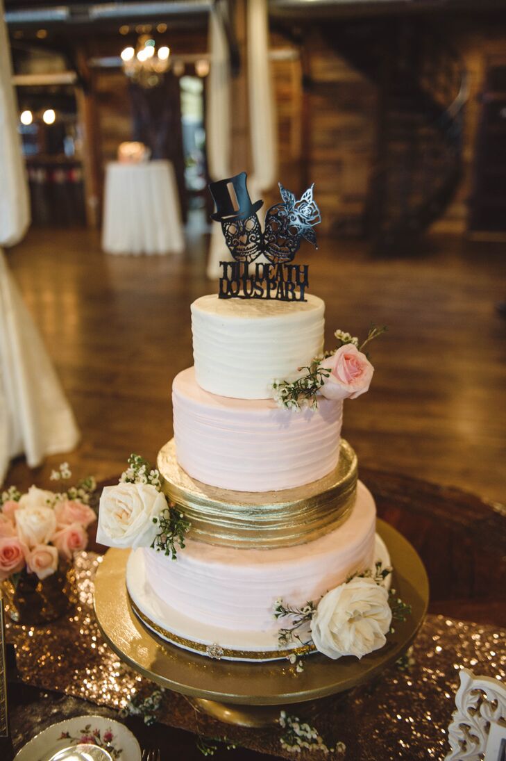 Laura and Levi’s cake from Madison’s on Main embodied the garden glam theme. It had a metallic gold tier in the center of blush and ivory tiers accented by garden roses, and a whimsical skull cake topper in black.
