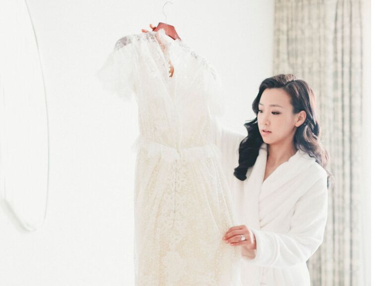 Bride in robe looking at wedding dress