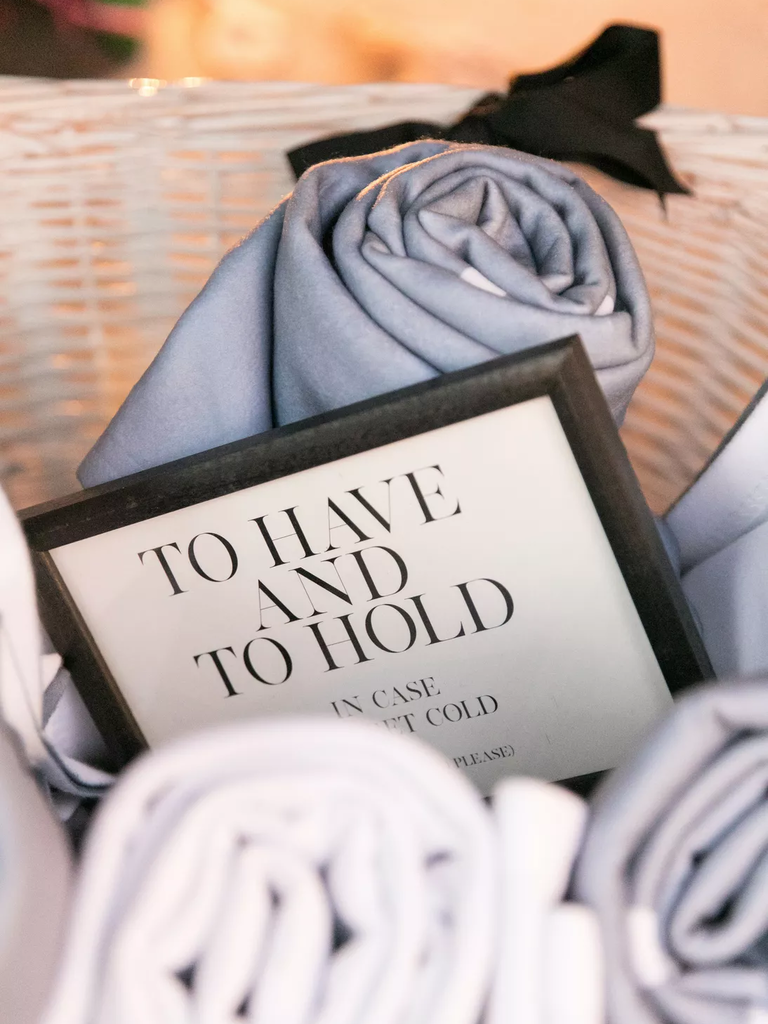 A basket of soft blanket wedding favors in neutral tones.