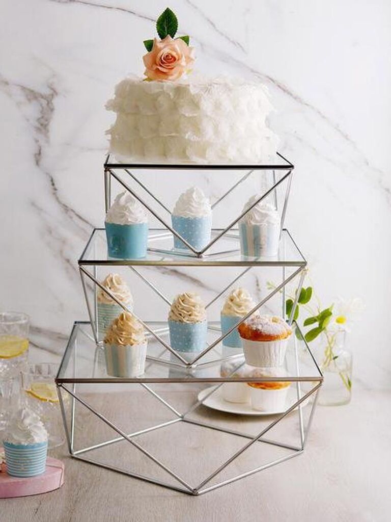Set of three metal geometric tiered wedding cake stand with single-tier cake on top