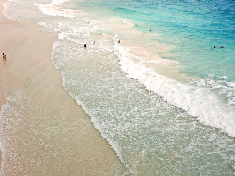 People swim in the turquoise waters of a Barbados beach. 
