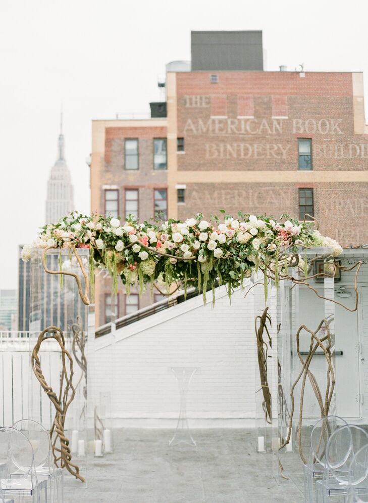 Mia and Jake’s chuppah perfectly reflected the couple’s modern, romantic vision with its fusion of natural and contemporary elements. Curly willow branches and Plexiglas columns served as the base for the striking structure, while a cascading garland of green amaranth, greenery, vines and blush and ivory blooms brought a secret-garden feel to the decor.